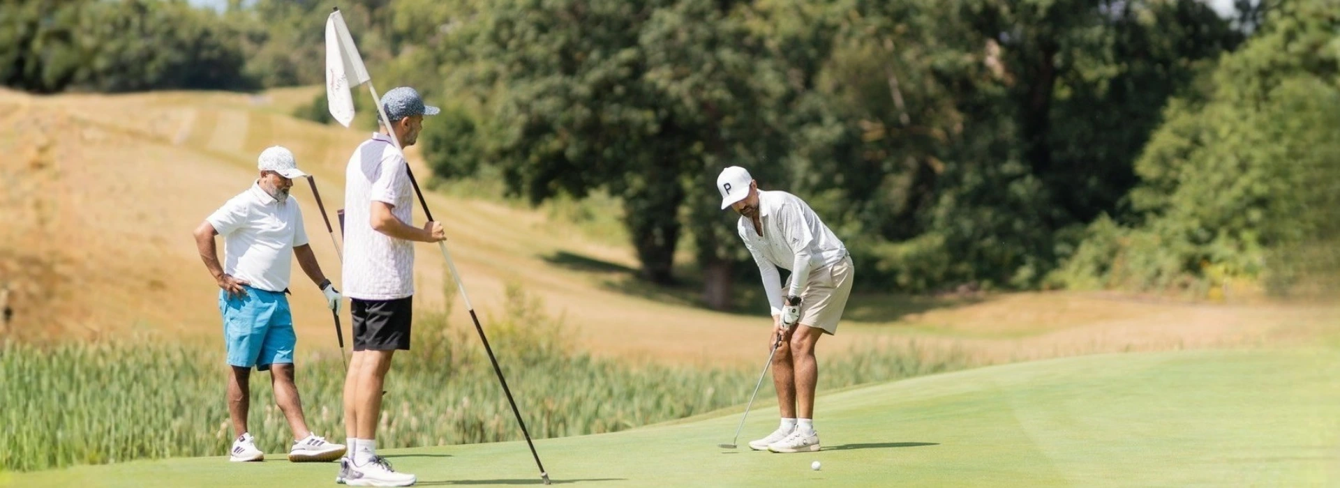 Golfers putting on the green during the Fairway Masters Invitational